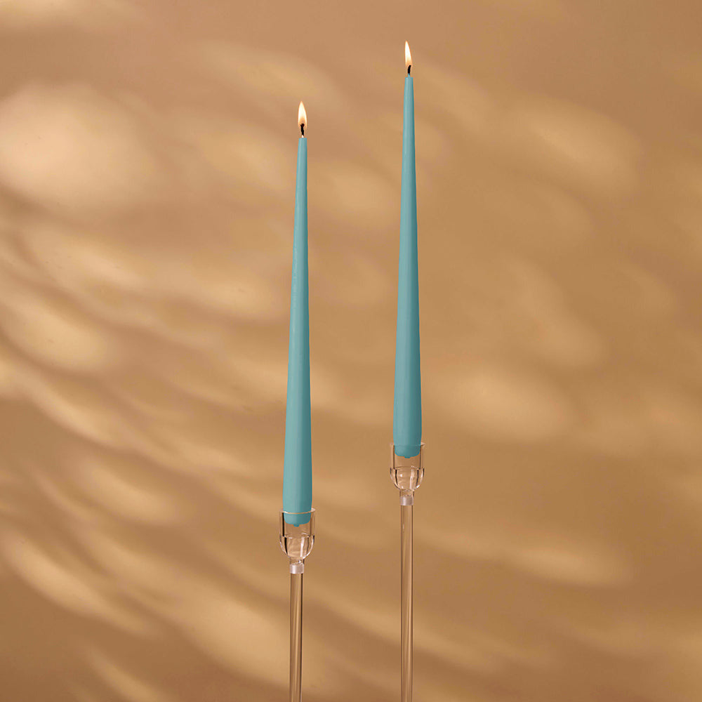 Two blue candles with clear holders on a brown background