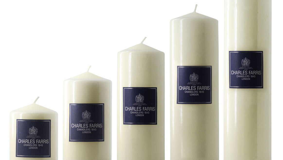 Set of five white candles with blue labels on a white background