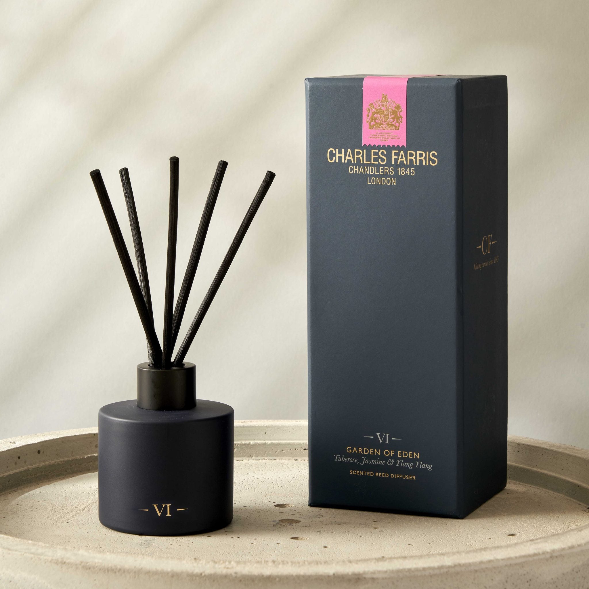 Reed diffuser with sticks and its packaging on a neutral background