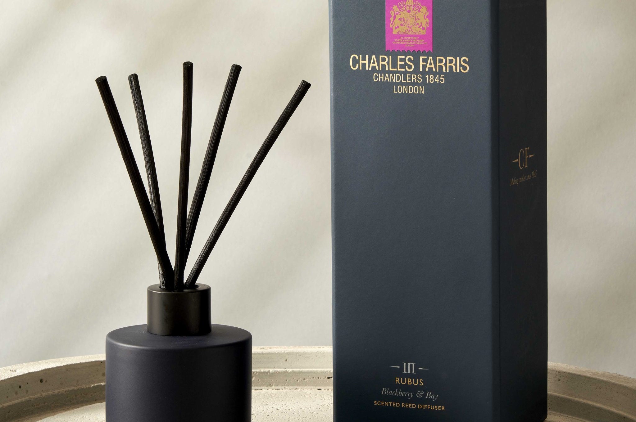 Blue diffuser with sticks and its packaging on a neutral background