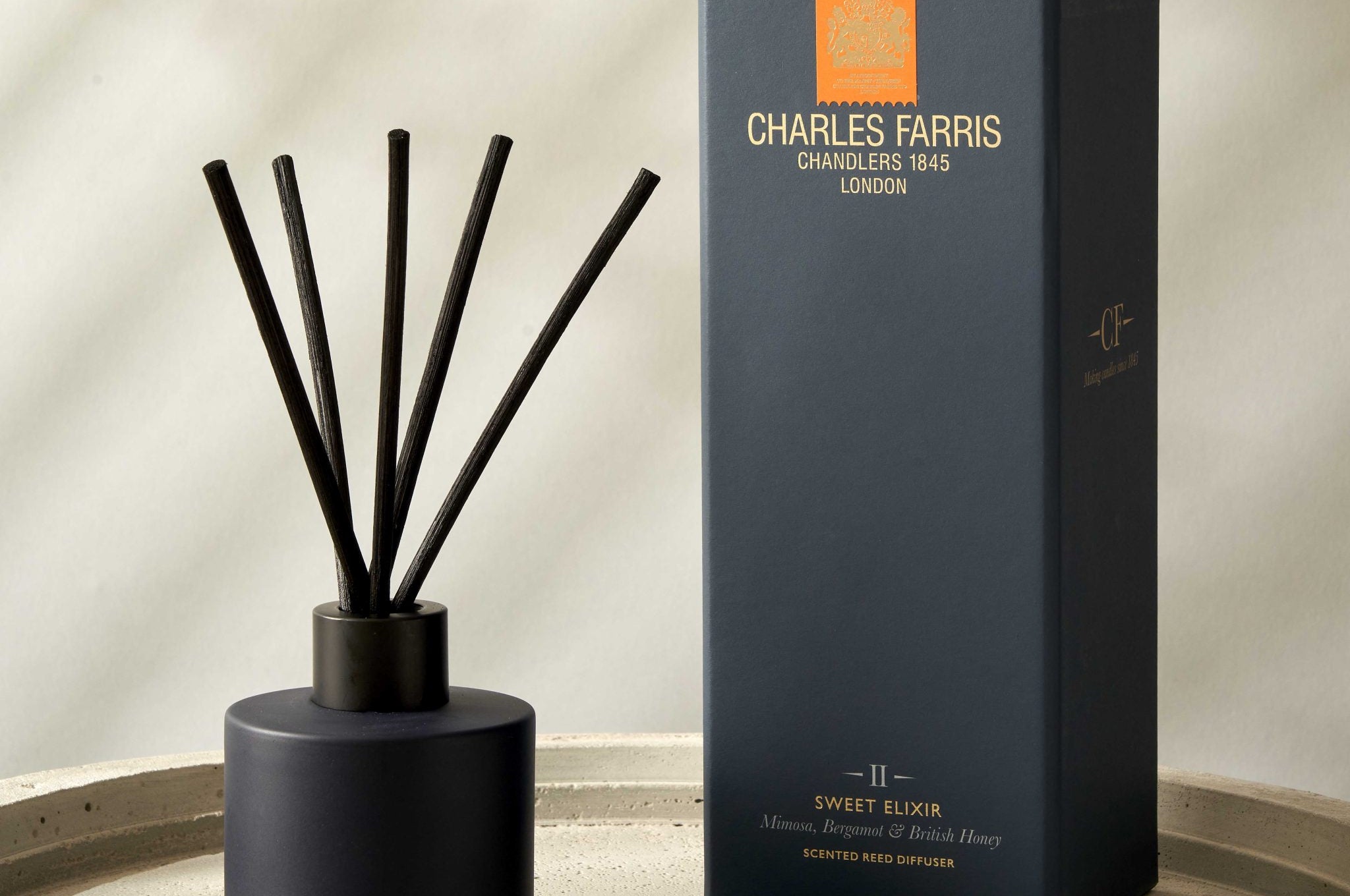 Blue diffuser with sticks and its packaging on a neutral background