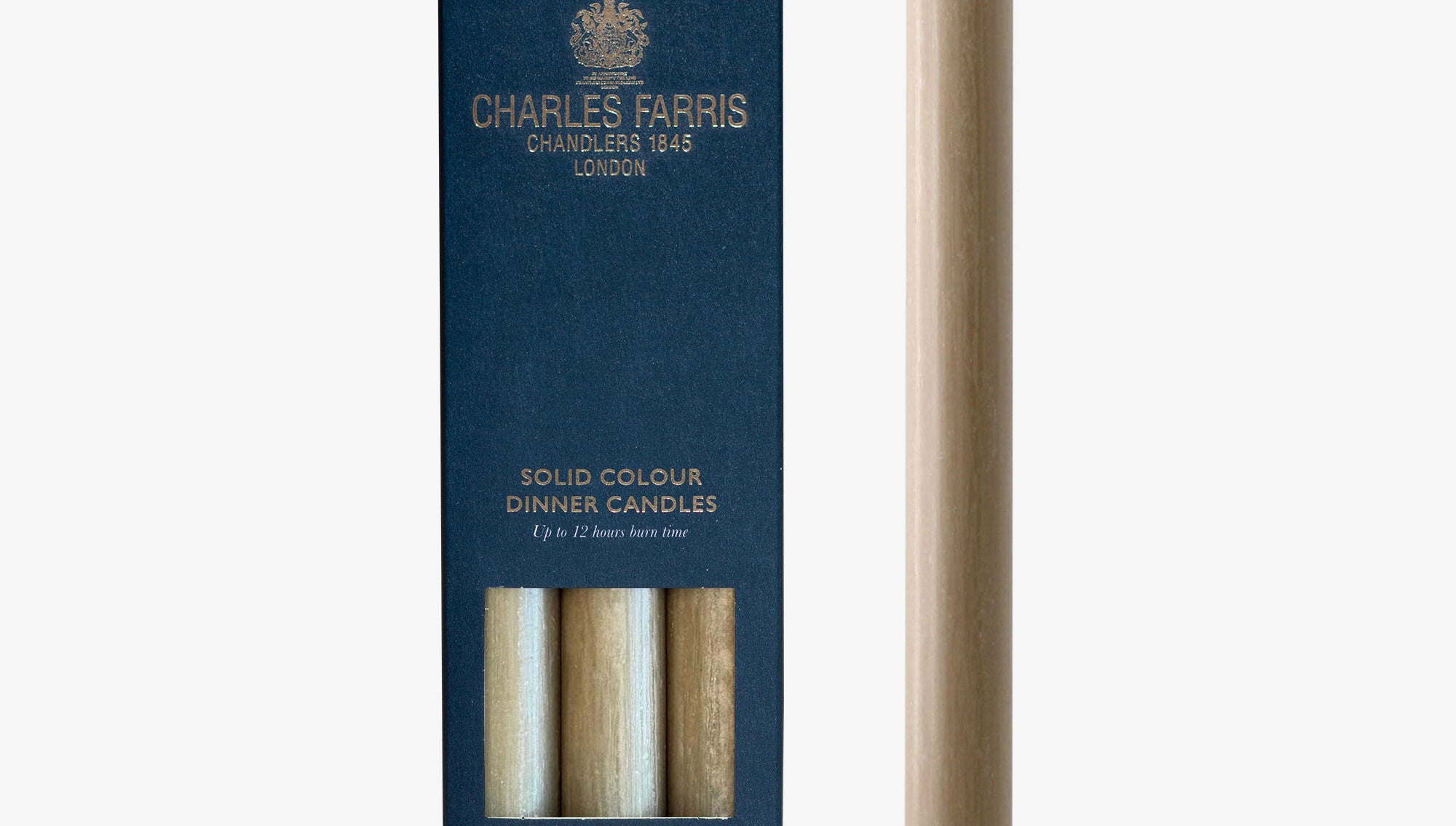Clay colour dinner candle next to its packaging with 'Charles Farris' branding on a white background