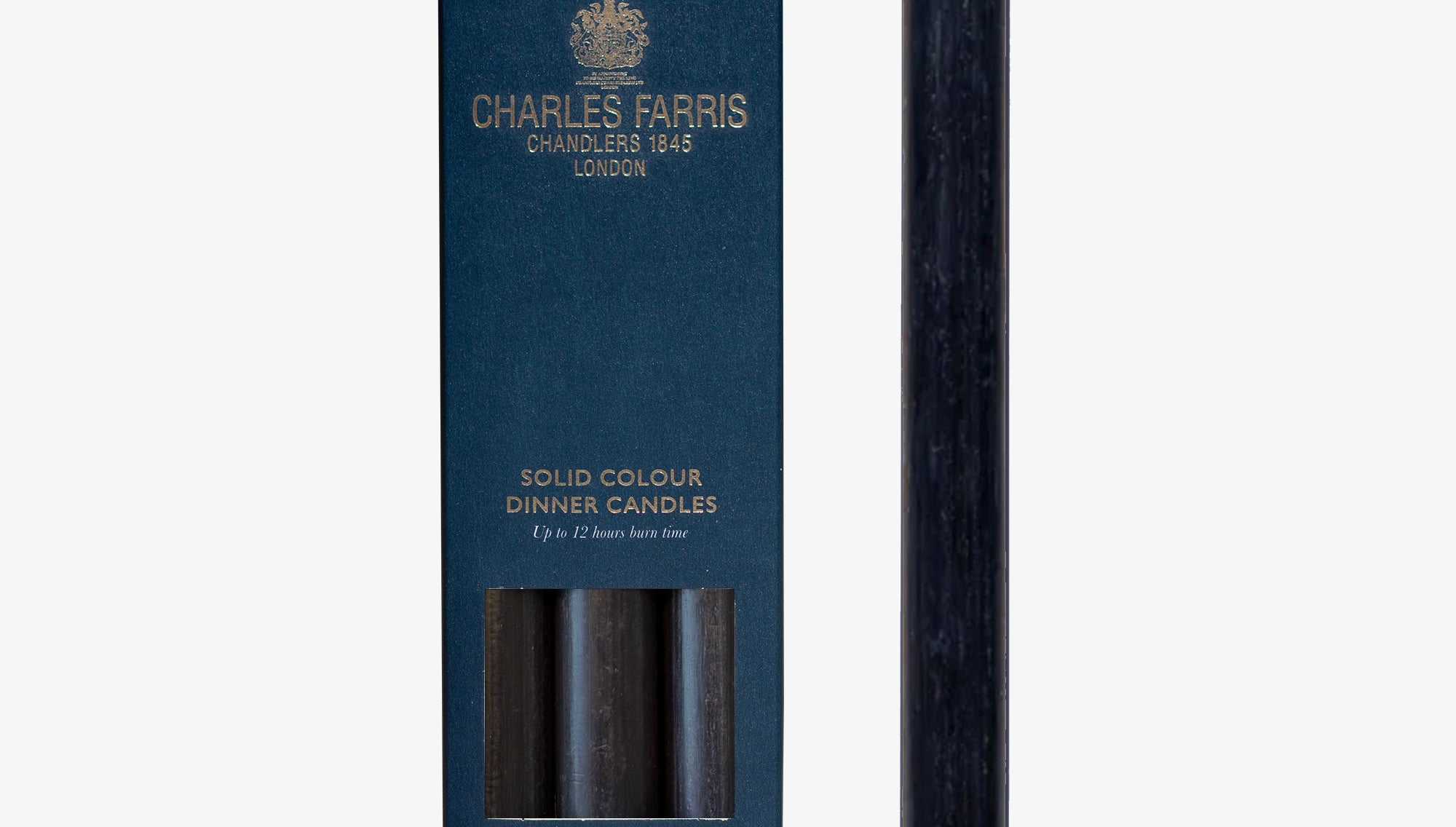 Dark blue candle next to its packaging box with 'Charles Farris' branding on a white background