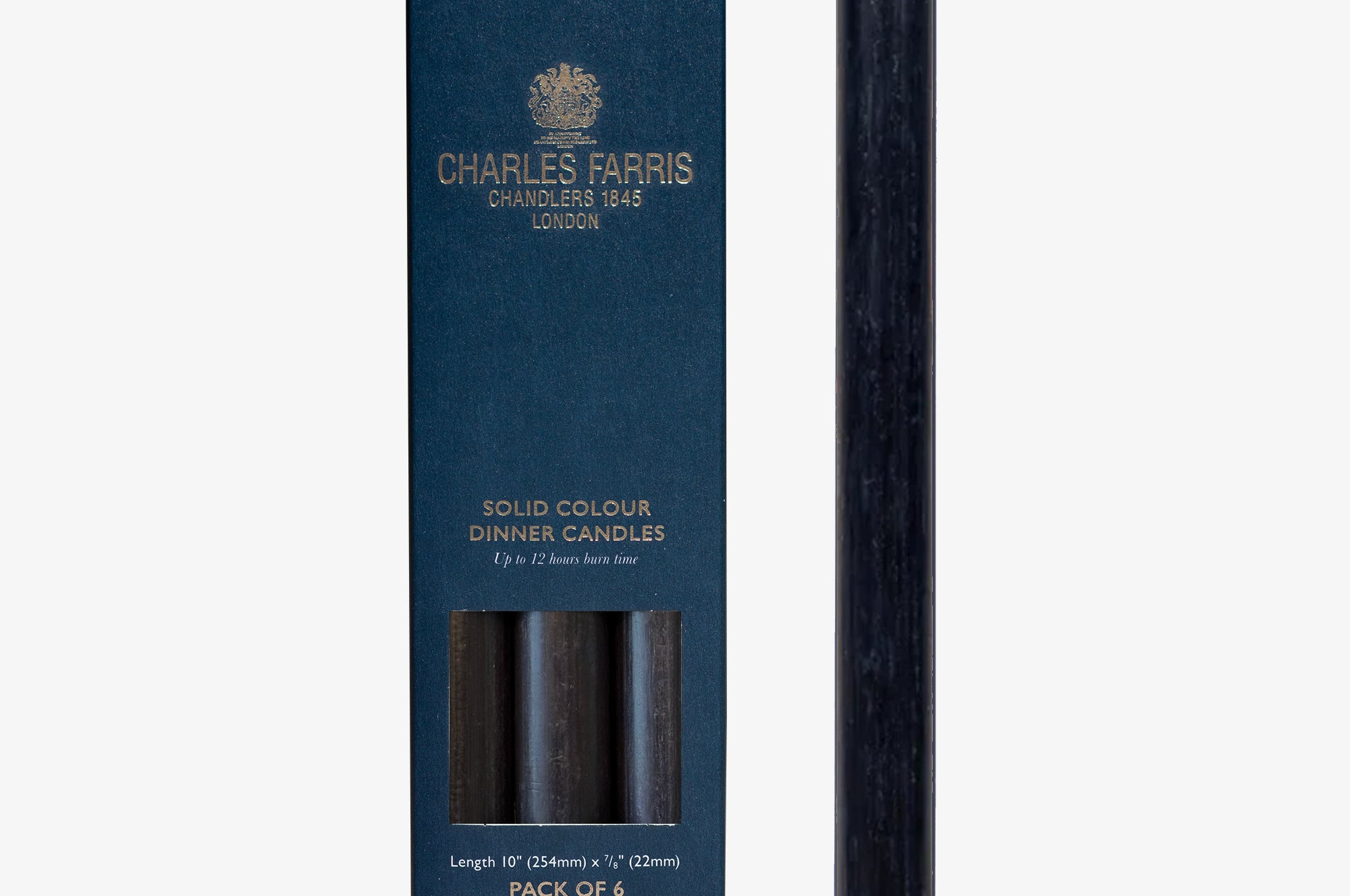 Dark blue candle next to its packaging box with 'Charles Farris' branding on a white background