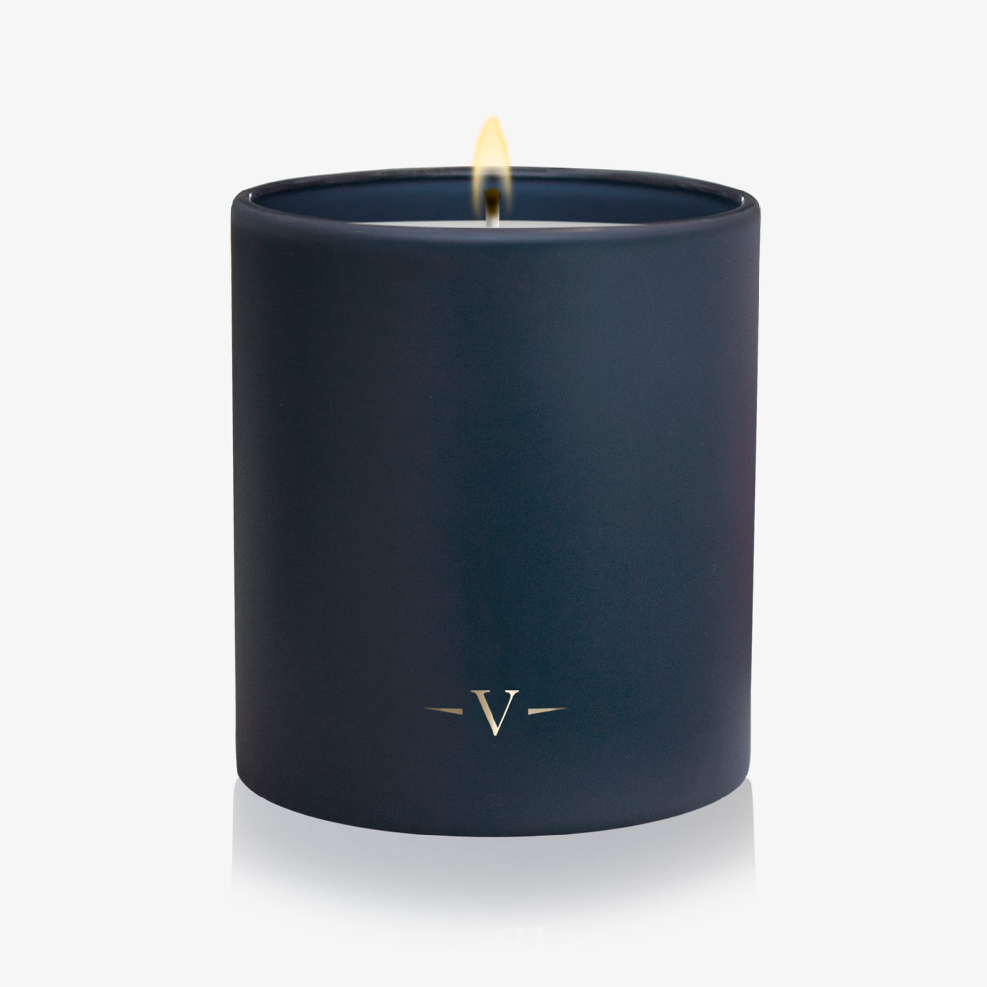 Navy blue candle with a lit wick on a white background