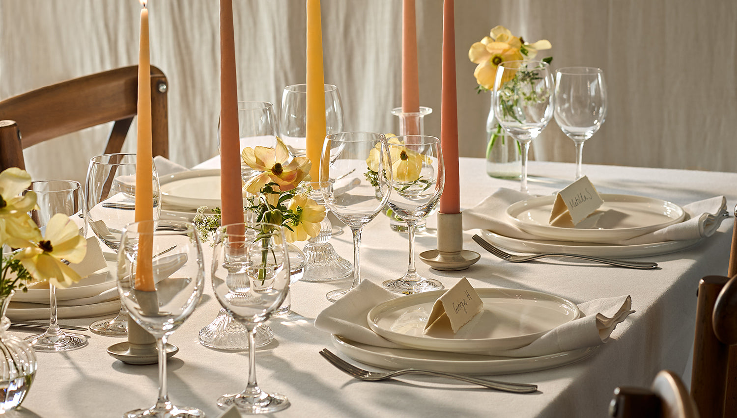Lit tapered candles on a dining table for a wedding