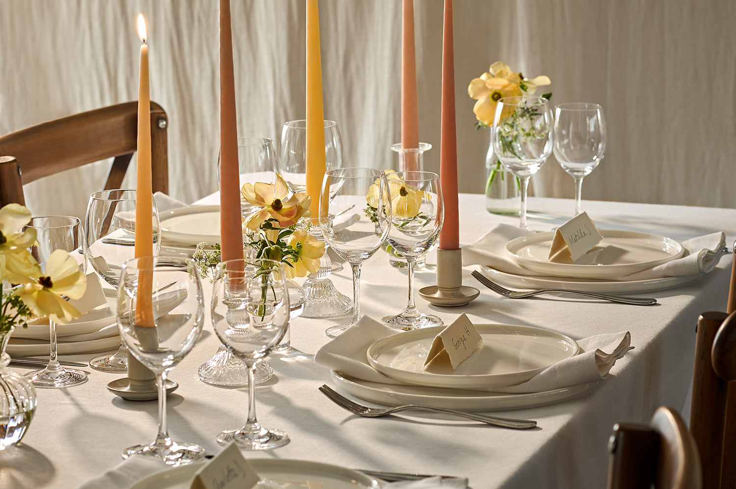 Lit tapered candles on a dining table for a wedding