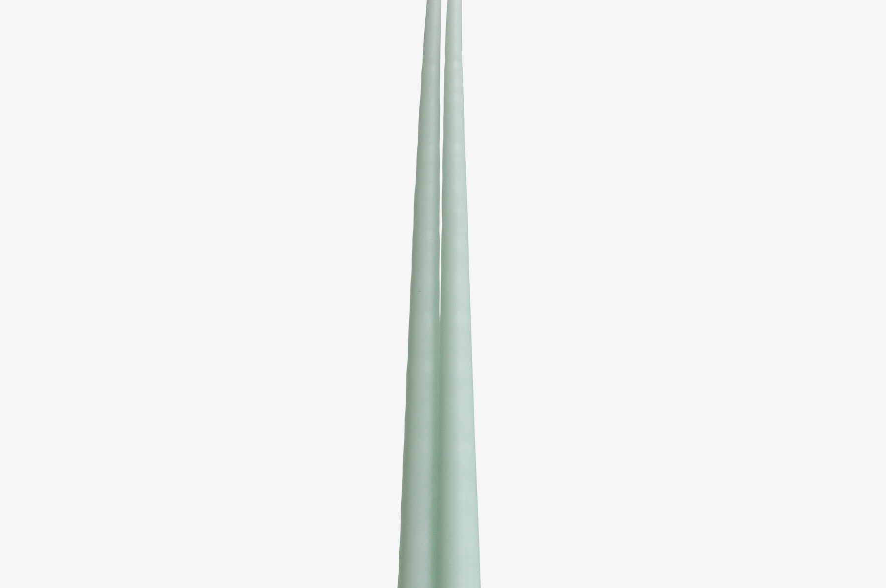 Two light green candles on a white background