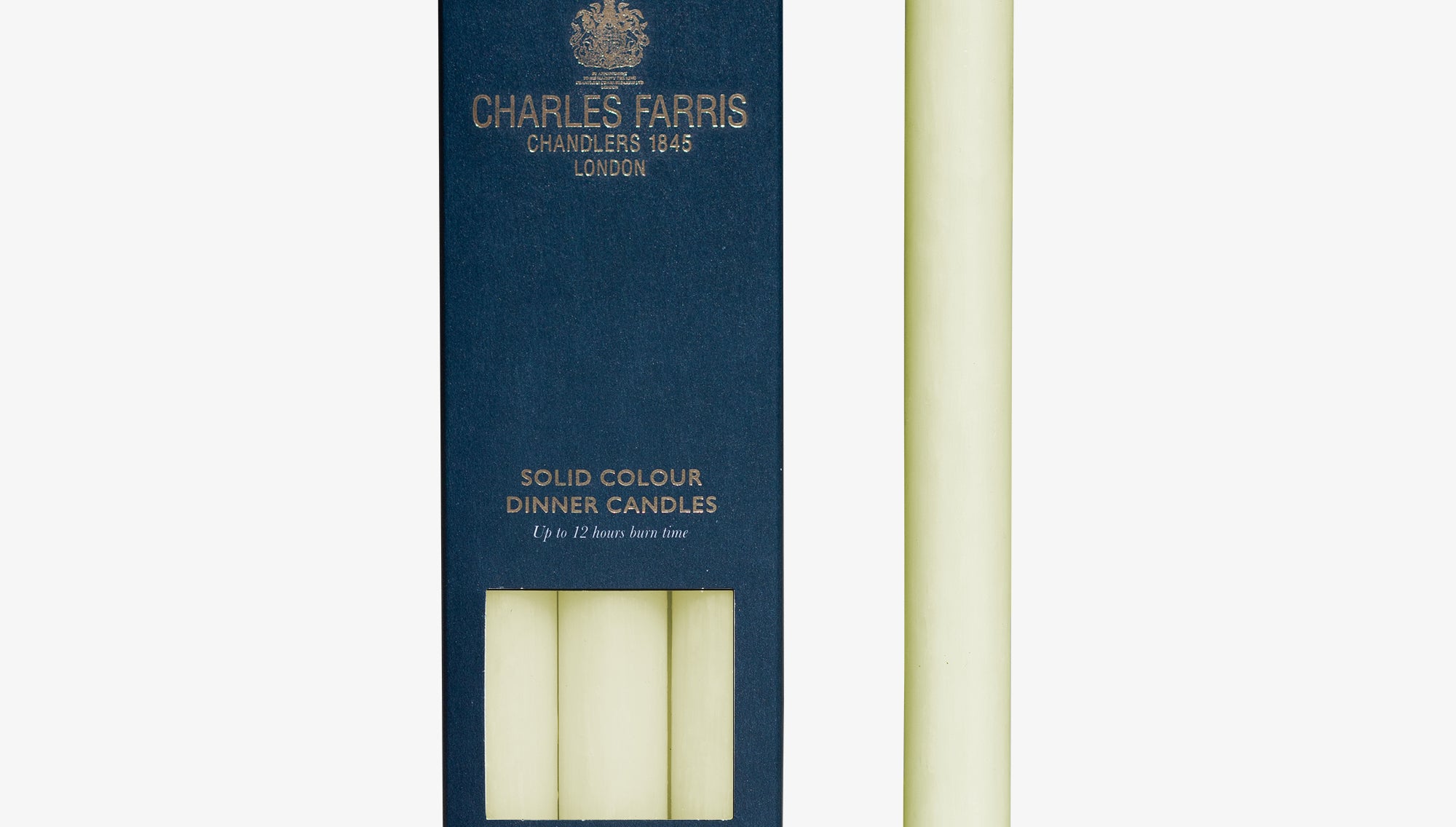 Ivory dinner candle next to its packaging with 'Charles Farris' branding on a white background