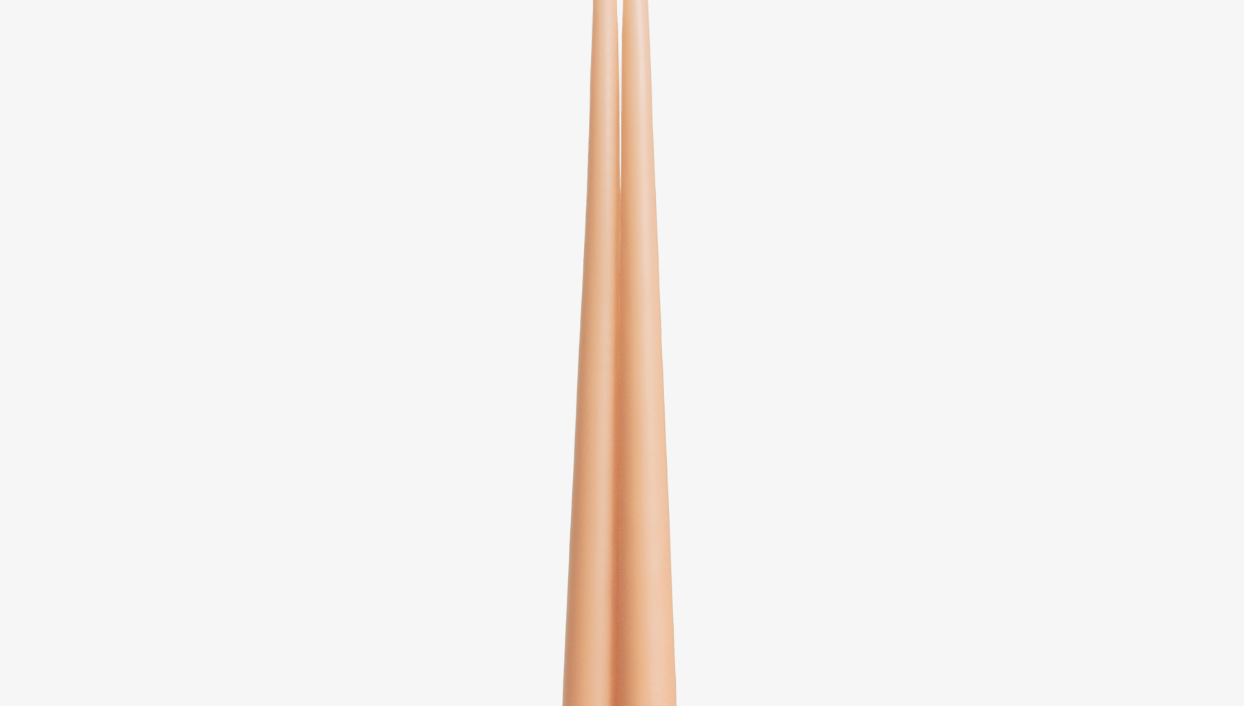 Two rose gold candles on a white background