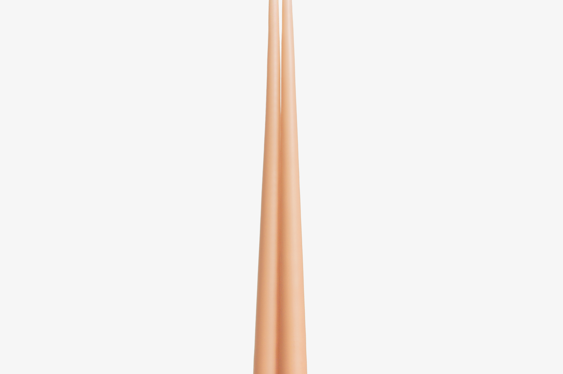 Two rose gold candles on a white background