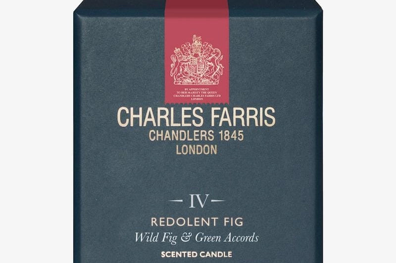 Blue box of Charles Farris scented candle with red ribbon on a white background