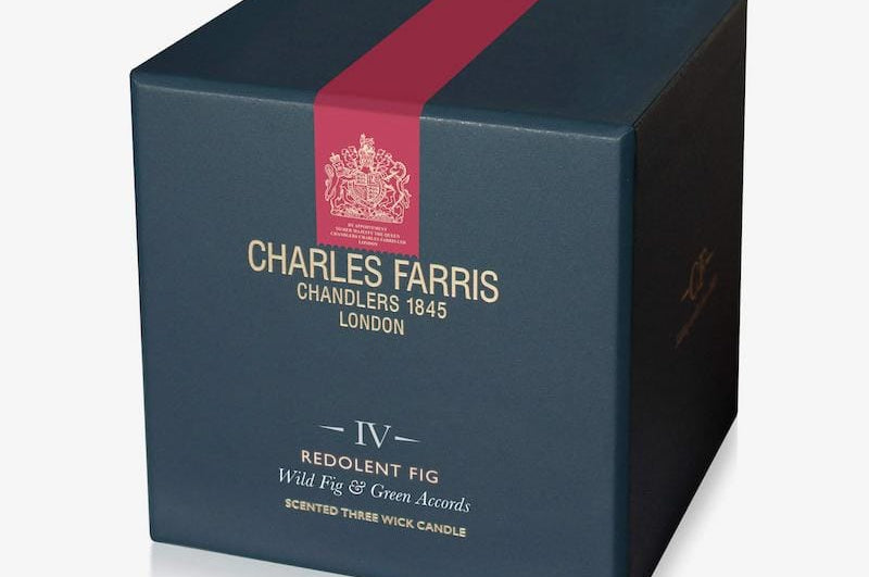 Dark blue candle box with red ribbon featuring Charles Farris branding on a white background