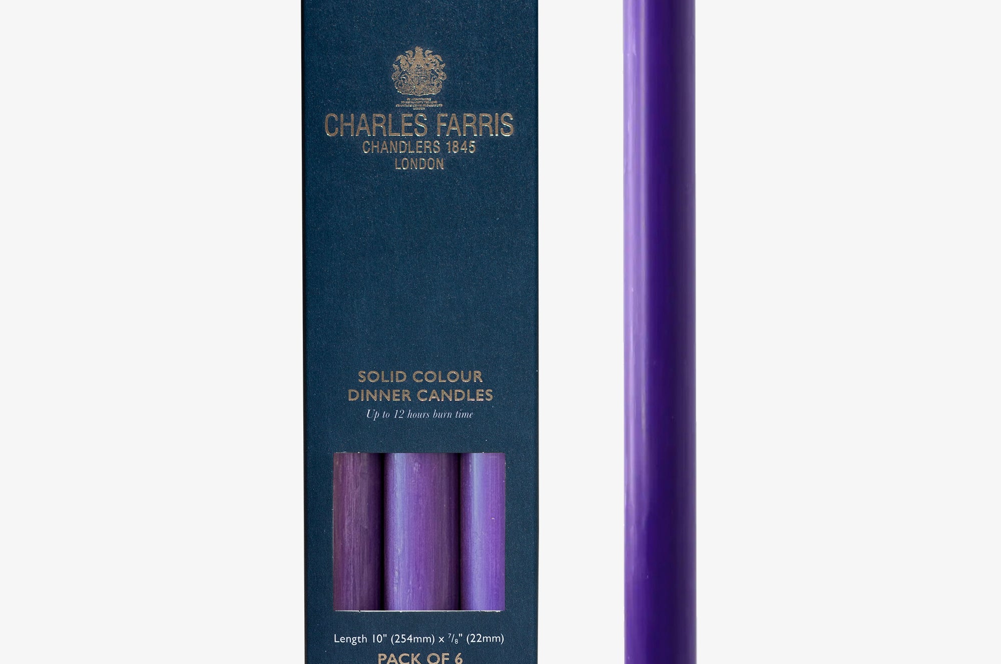 Purple candle next to its packaging with 'Charles Farris' branding on a white background