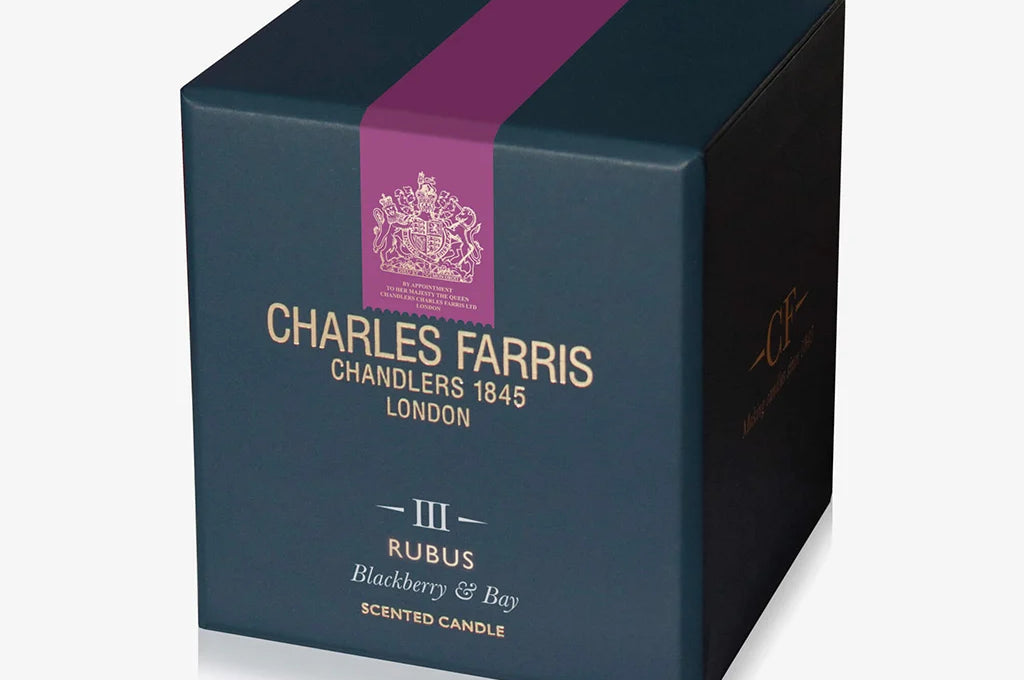 Dark blue candle box with purple stripe featuring Charles Farris branding on a light gray background