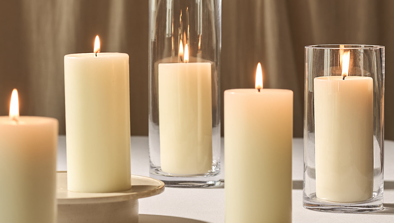 A collection of lit scented pillar candles
