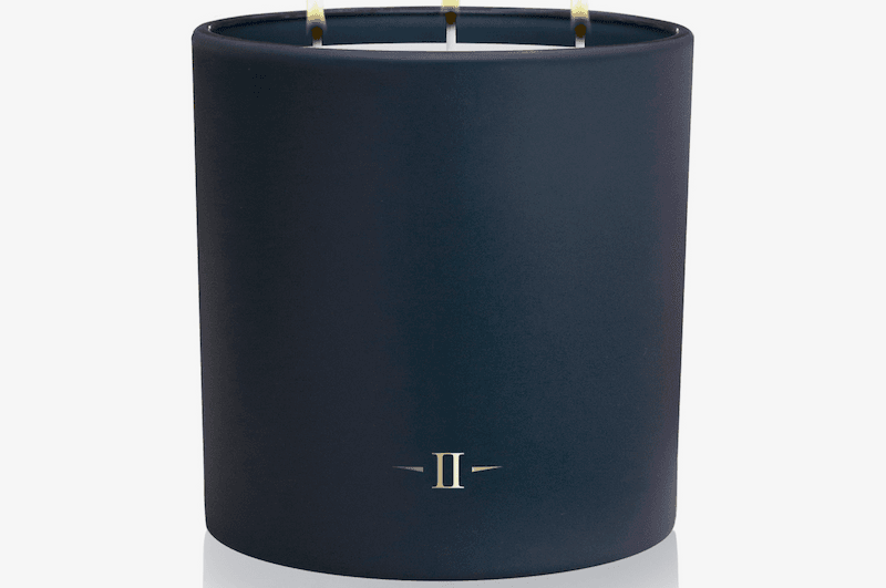 Navy blue candle with three wicks on a white background