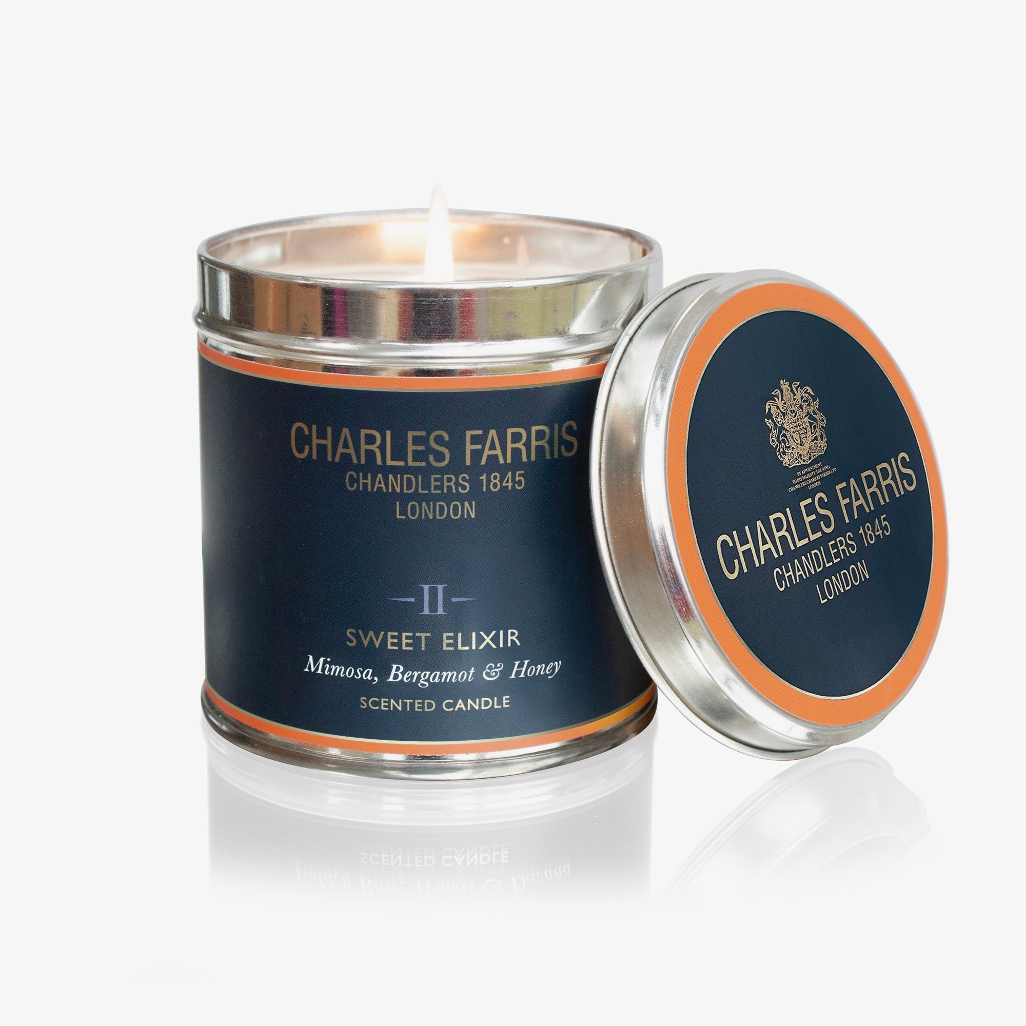Charles Farris Sweet Elixir scented candle with lid open on a white background