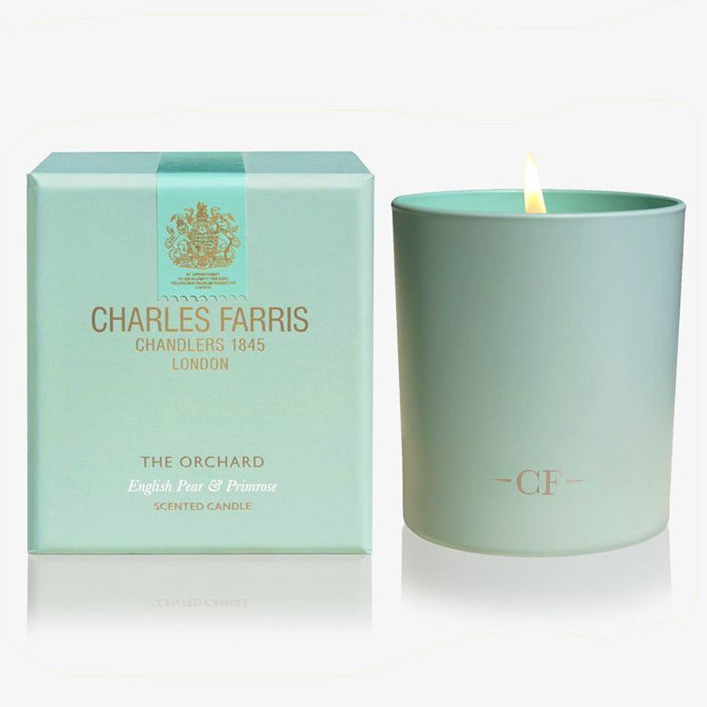 Mint green candle with 'Charles Farris' branding next to its packaging on a white background