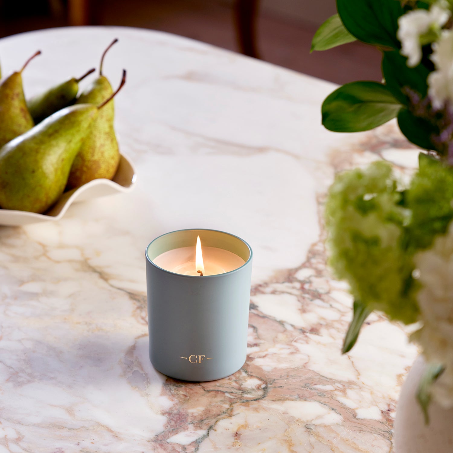 The Orchard jar candle on a marble surface with pears and flowers