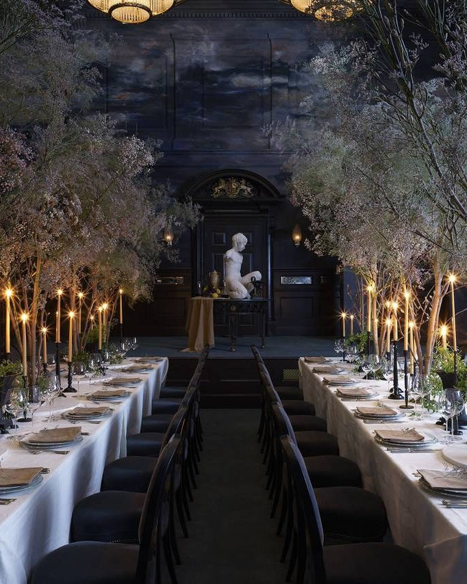 Candlelit private dining room set with tall Charles Farris dinner candles and trees for a corporate event