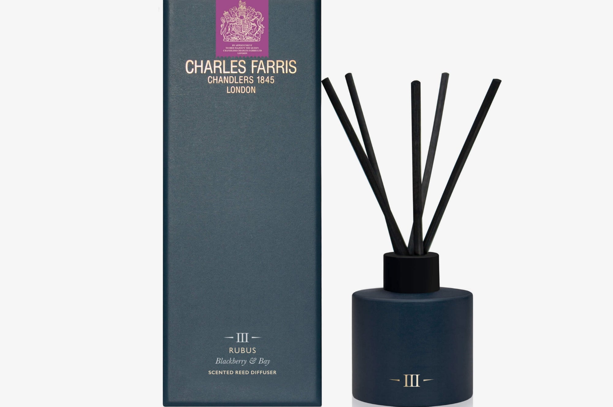 Diffuser with black sticks and a blue container next to its packaging on a white background