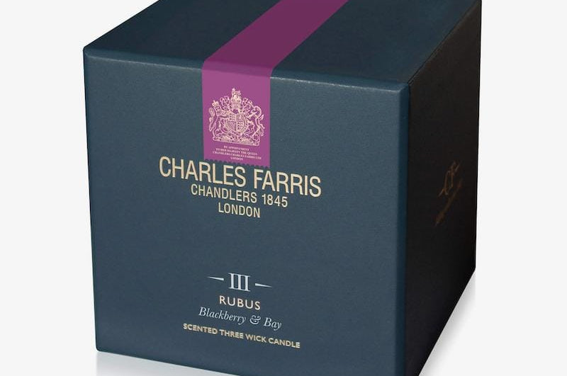 Blue candle box with purple ribbon and 'Charles Farris' branding on a white background