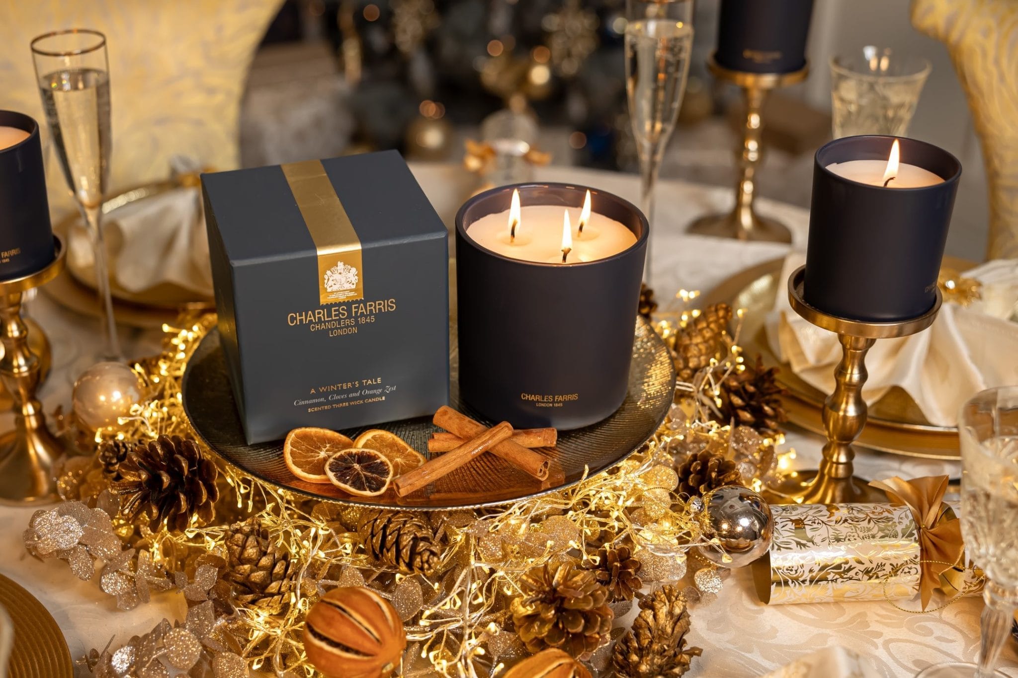 Decorative table setting with candles, a box, and festive decorations.