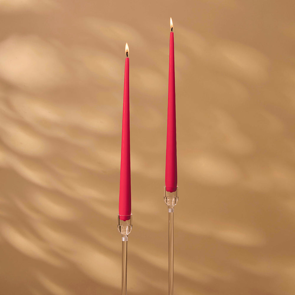 Two pink candles with clear holders on a beige background