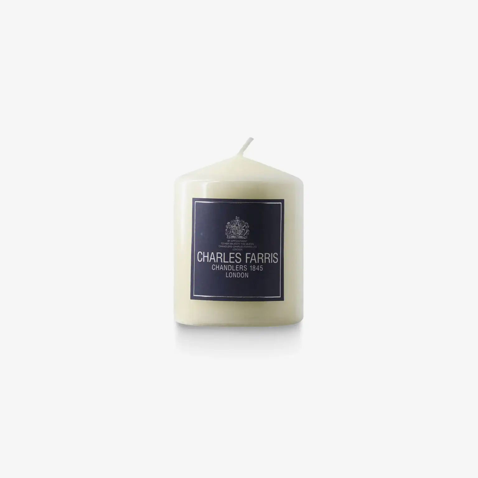 White candle with a dark label featuring 'Charles Farris' on a white background