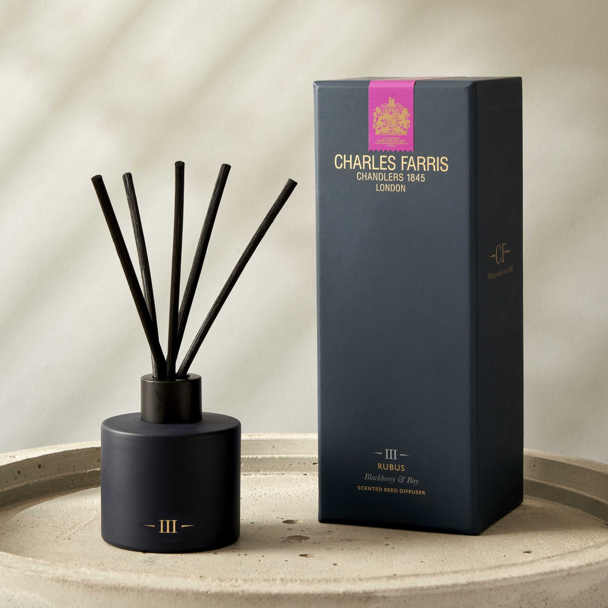 Blue diffuser with sticks and its packaging on a neutral background