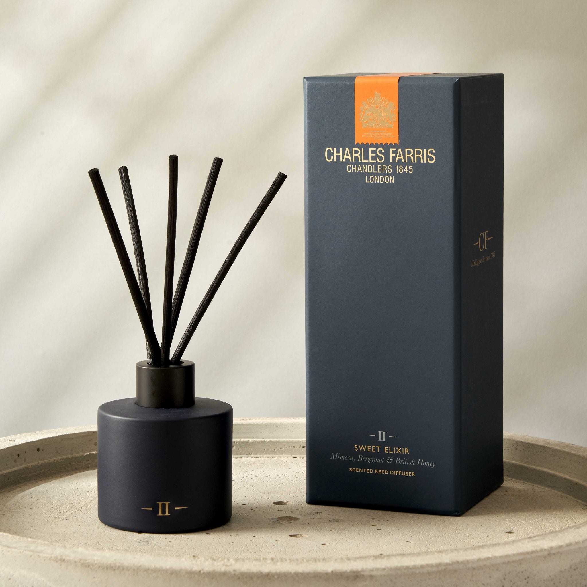 Blue diffuser with sticks and its packaging on a neutral background