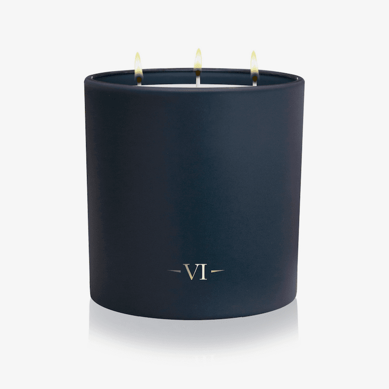 Navy blue candle with 'VI' logo on a white background