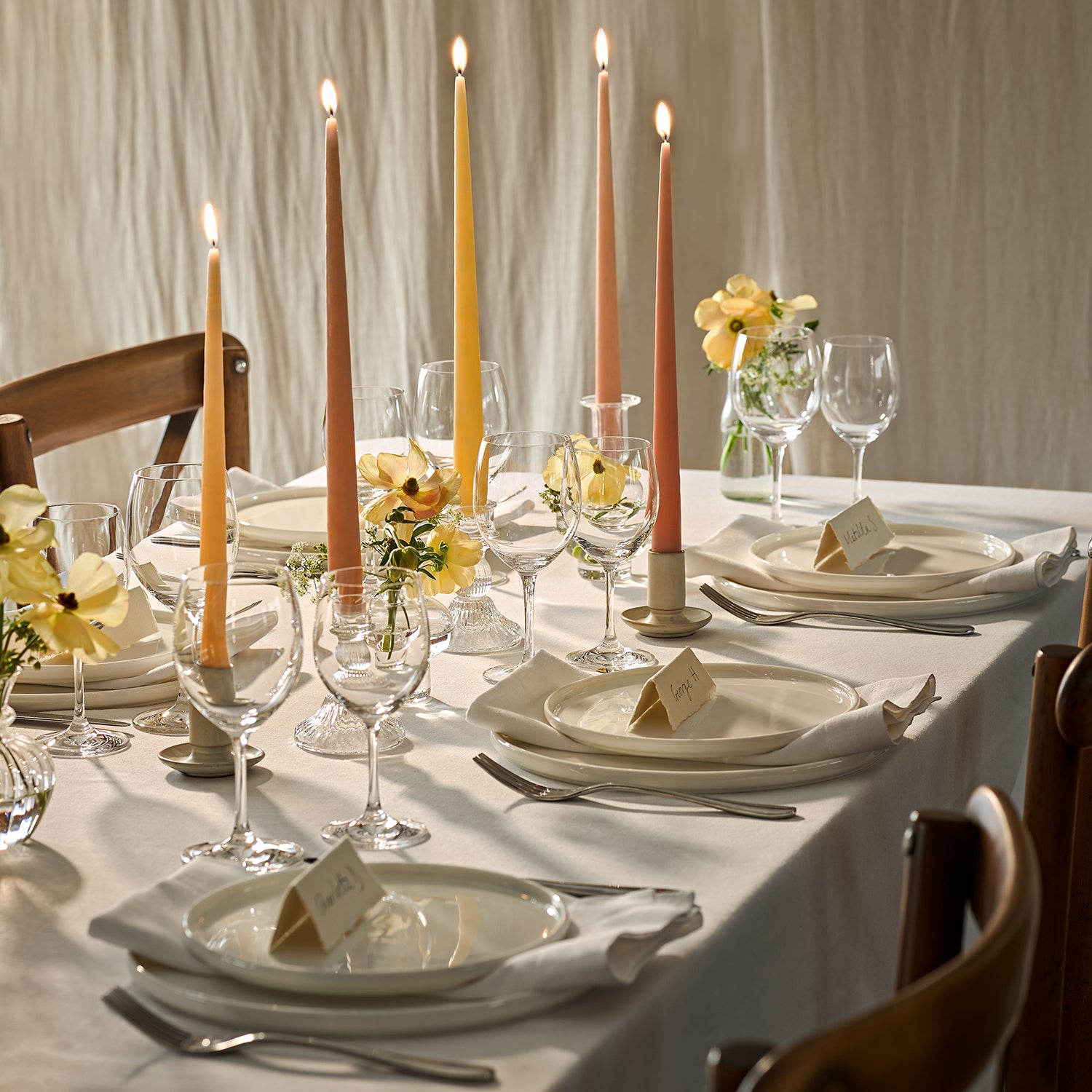 Lit tapered candles on a dining table for a wedding