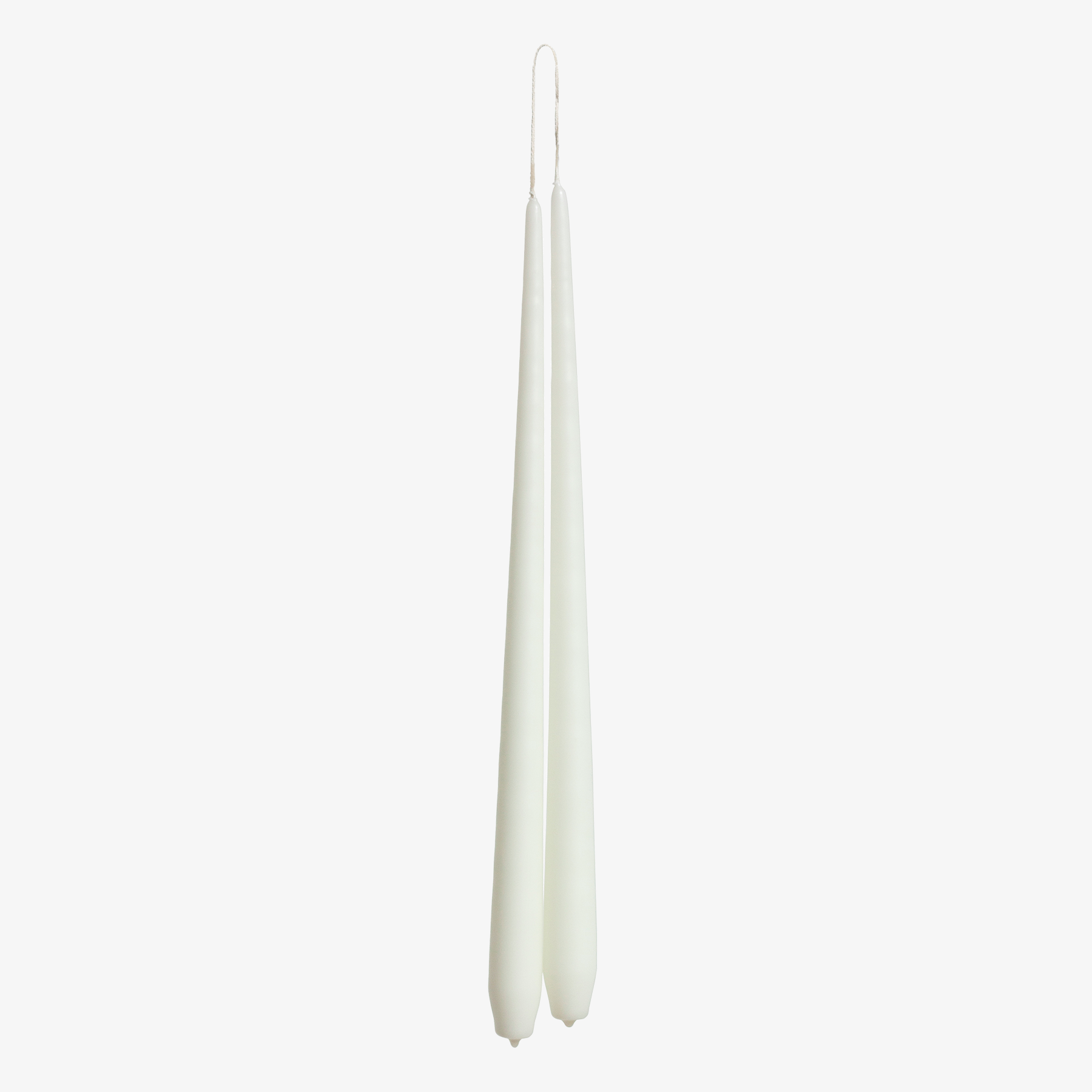 Two ivory white candles on a white background