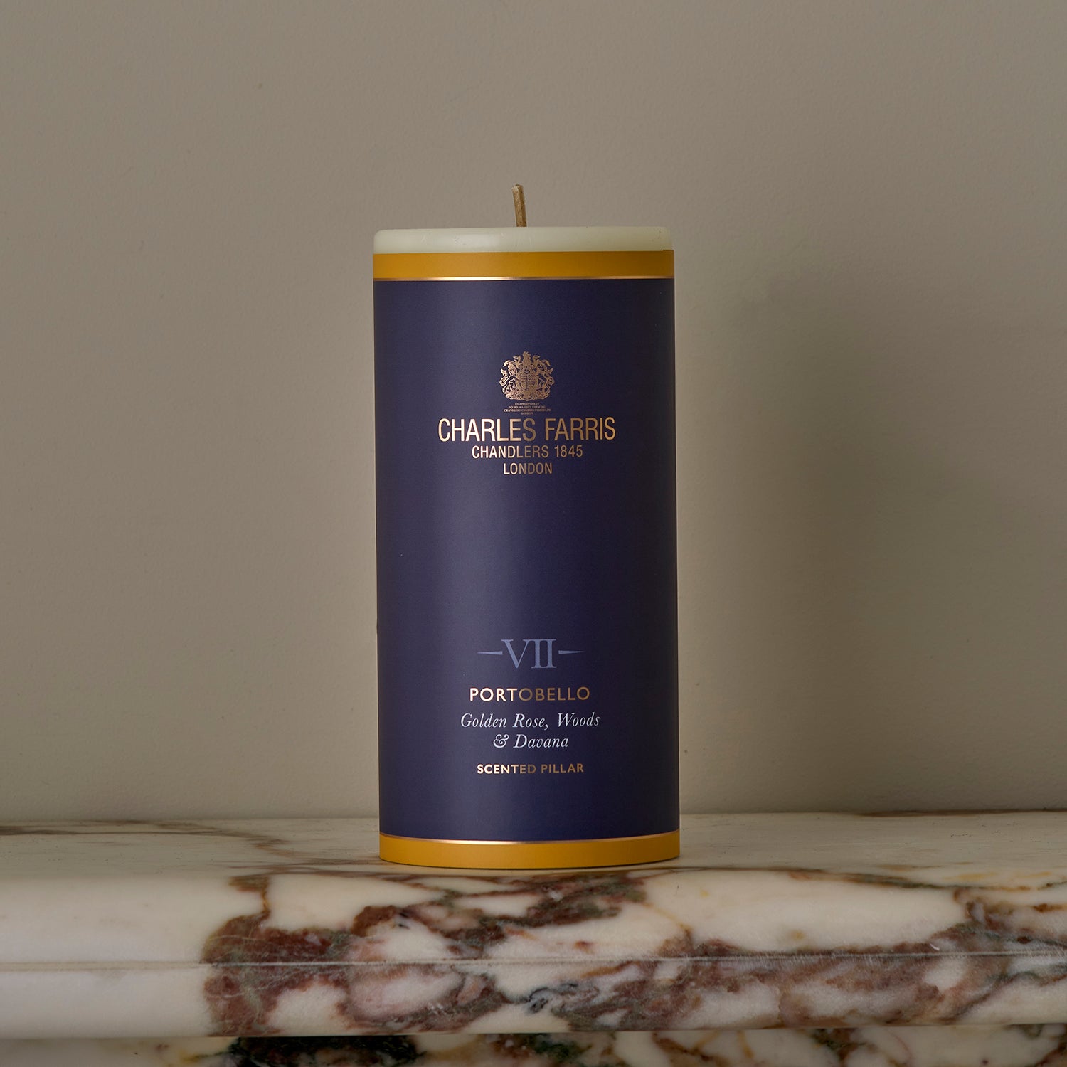 A Portobello Scented Pillar Candle on a marble surface.