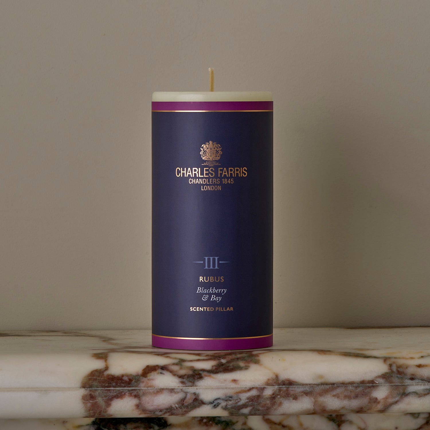 A Rubus Scented Pillar Candle on a marble surface.