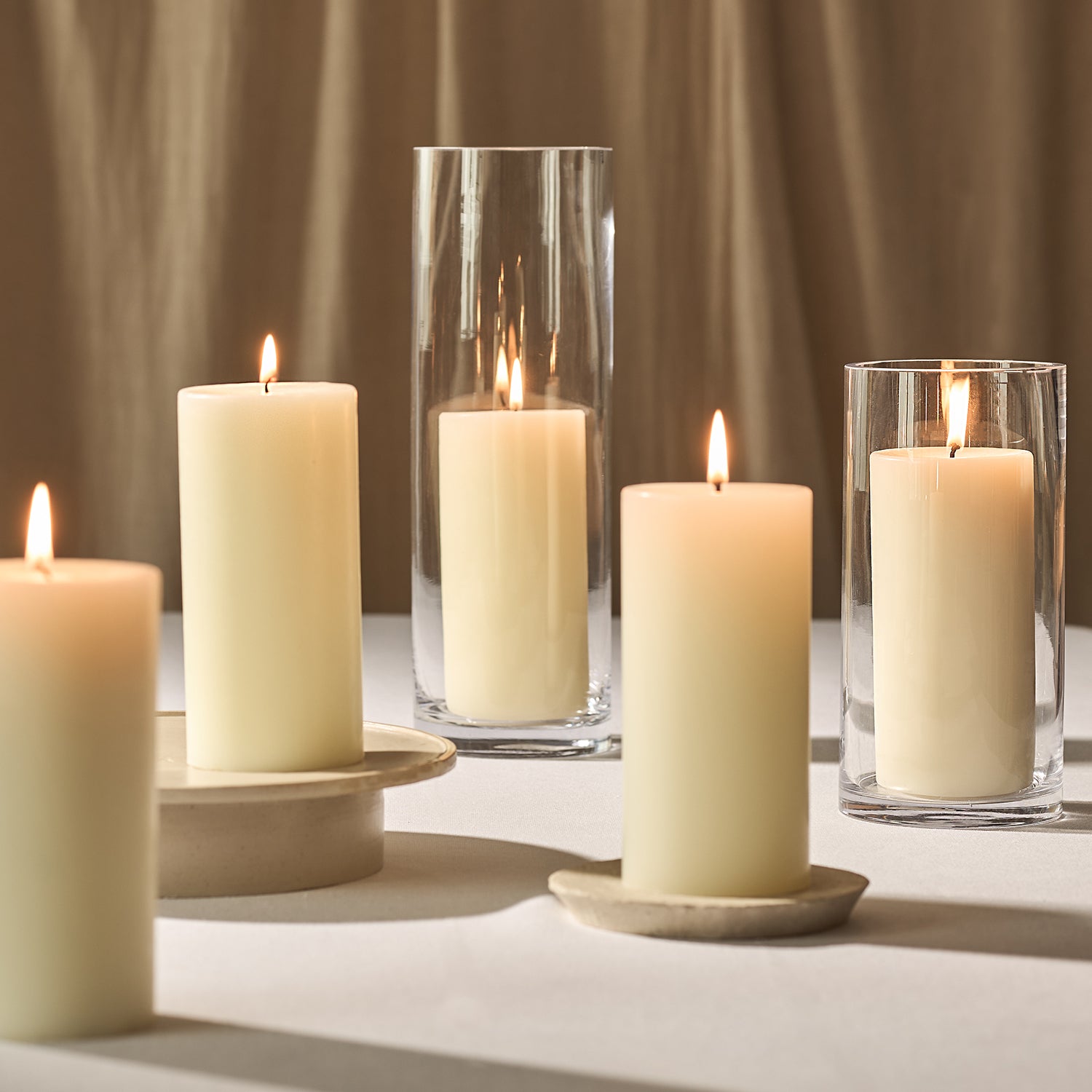 A collection of lit scented pillar candles
