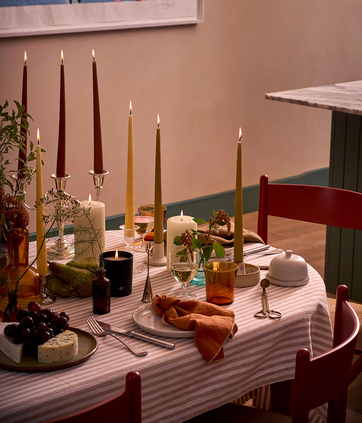 Charles Farris autumn table setting with tapered dinner candles, a scented candle, pears and amber glassware