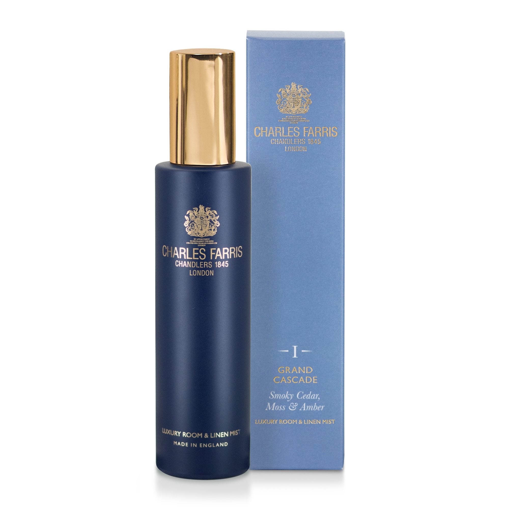 Charles Farris Grand Cascade oak, moss, amber room mist scented home spray in navy blue bottle next to its light blue packaging.