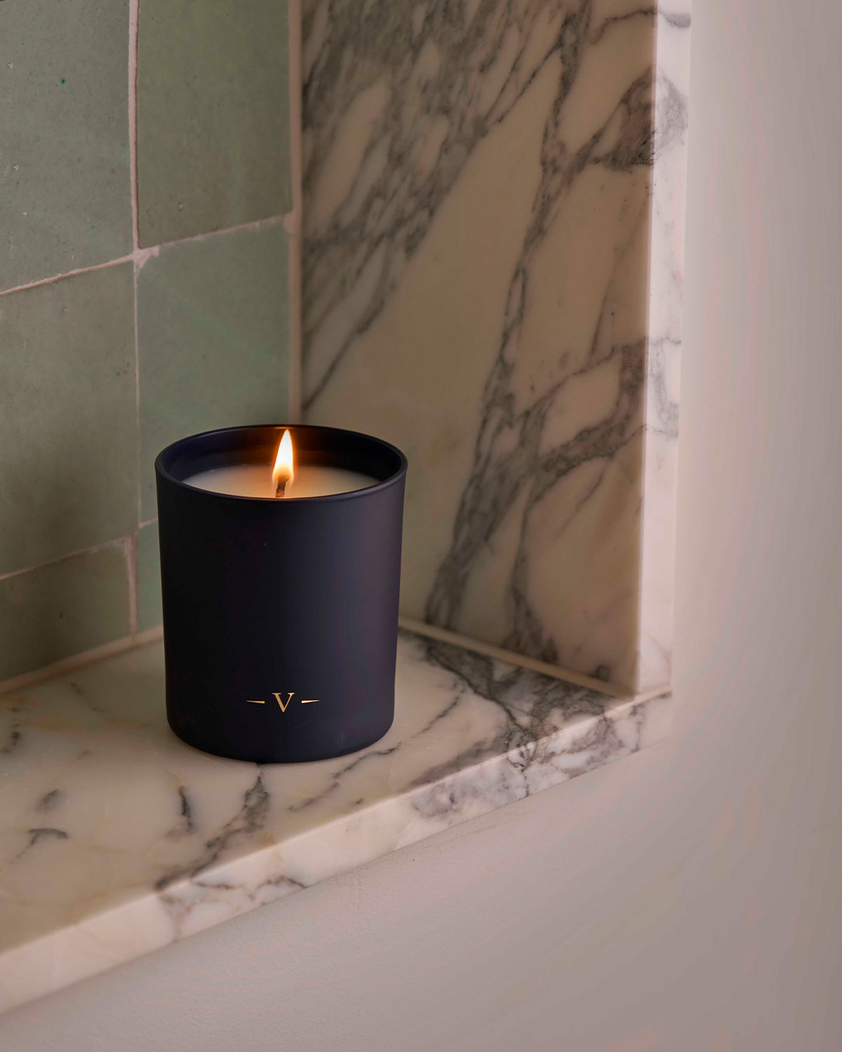 Charles Farris lit navy scented candle on a marble fireplace ledge, hand-poured in England