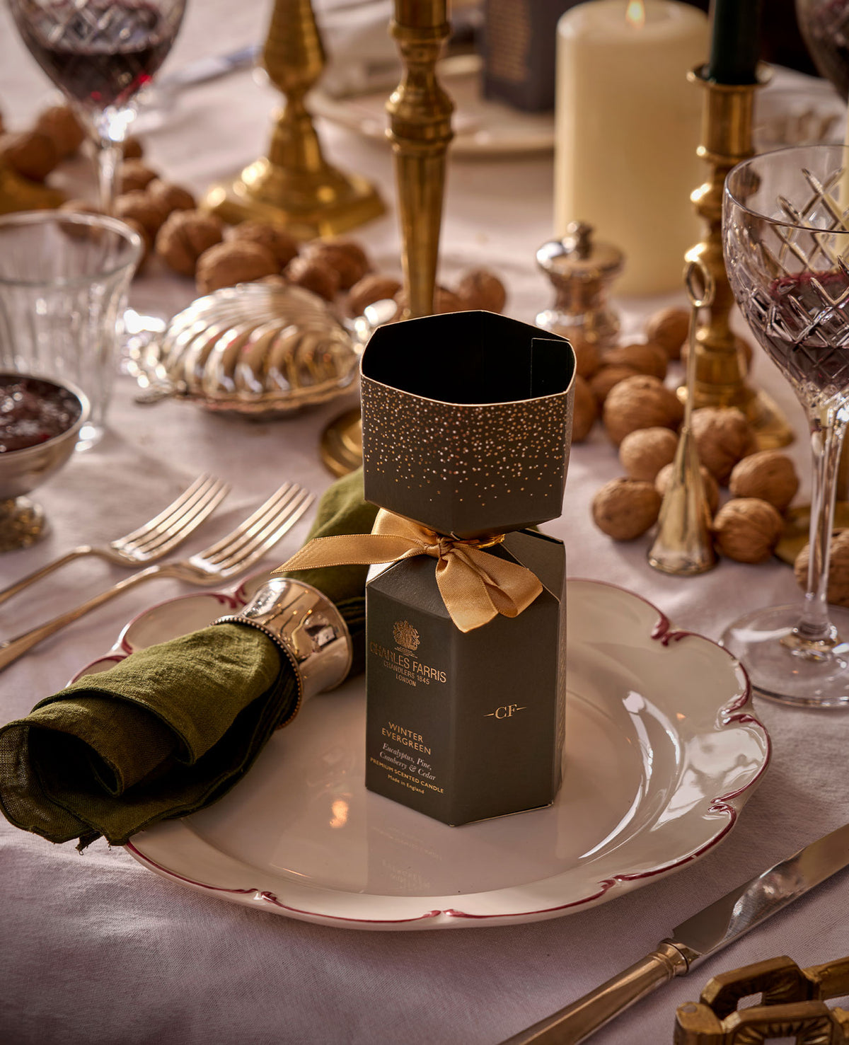 Charles Farris Christmas cracker candle on a place setting with walnuts and gold cutlery