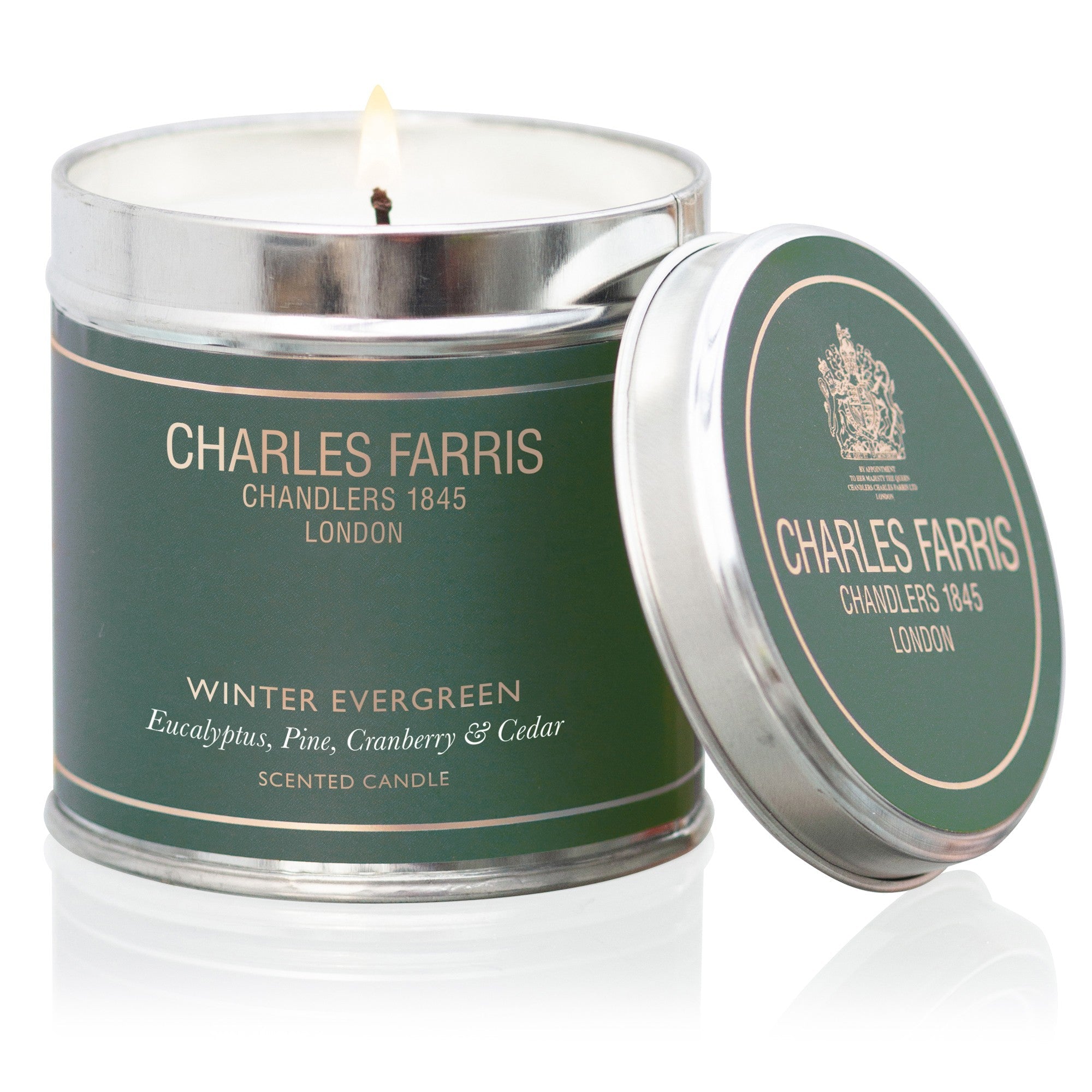 Charles Farris Winter Evergreen tin candle, lit, in eucalyptus, pine, cranberry and cedar