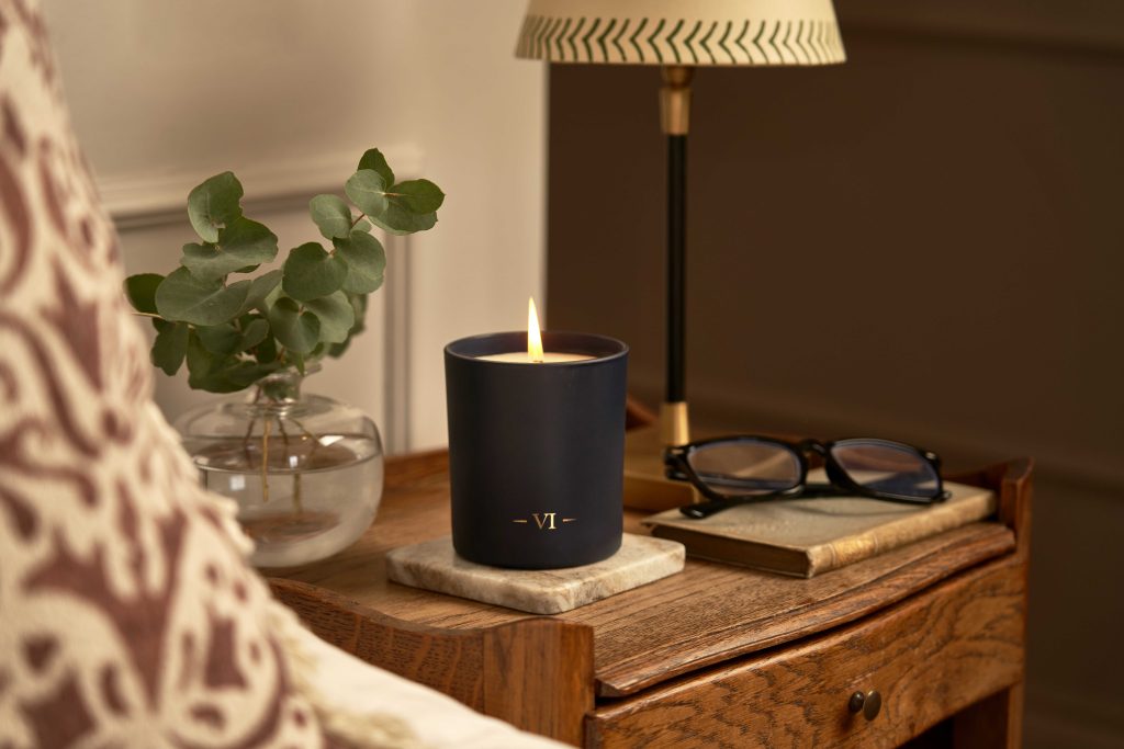 garden of eden scented candle burning on a table