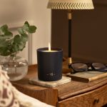 garden of eden scented candle burning on a table